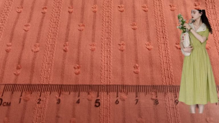 Close-up view of cotton jacquard fabric with dotted stripe pattern and intricate texture.